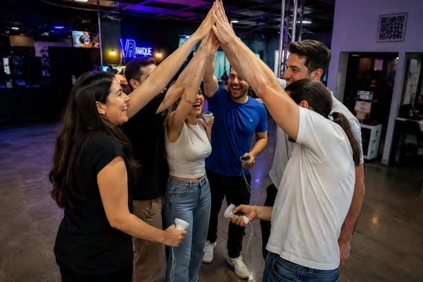 Colegas celebrando juntos com as mãos levantadas